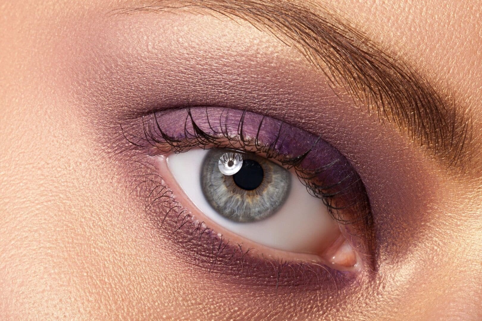 A close up of the eye with purple makeup